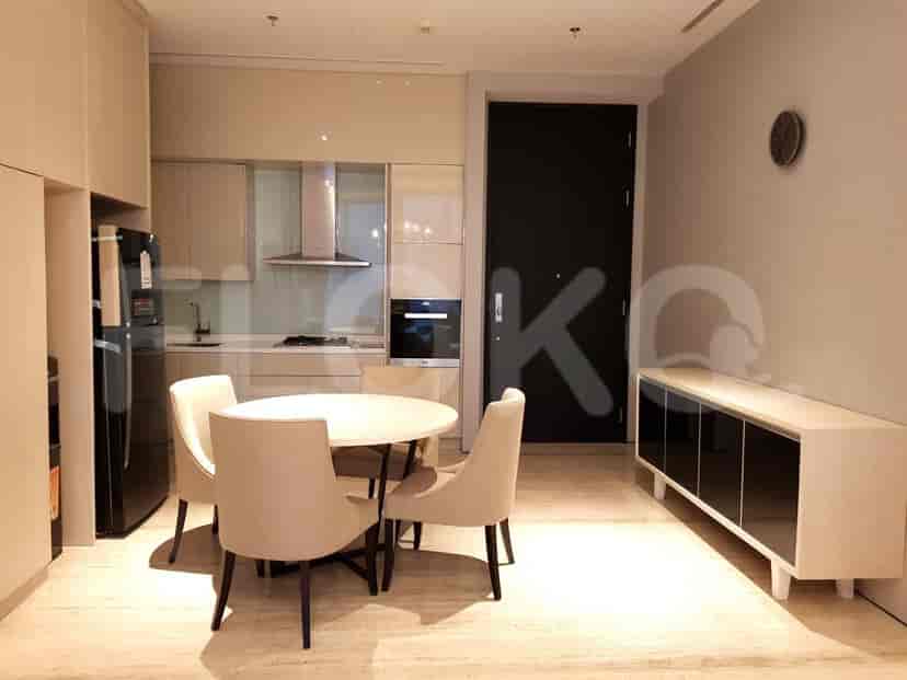 A modern dining area with a round table, chairs, and kitchen access.