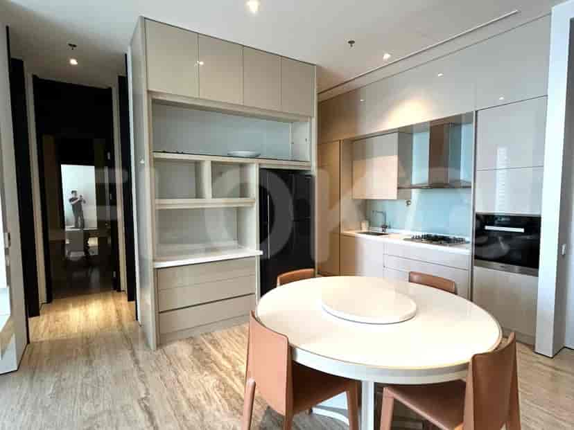 Kitchen with built-in cabinets, dining table, and a view of the hallway.