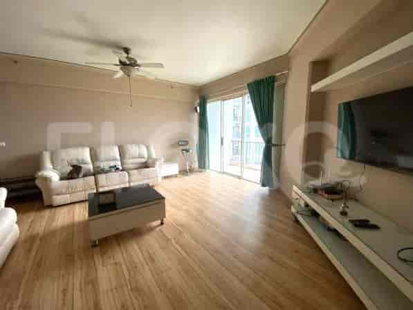 Ruang tamu yang luas dengan sofa putih, meja kopi, dan akses balkon.