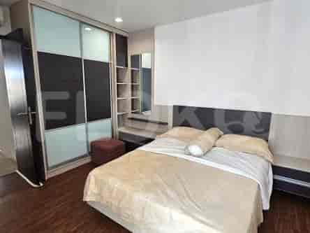 Bedroom with queen size bed and wooden flooring.