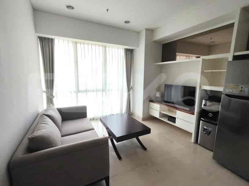 A modern living room with a grey sofa, TV, and large window.