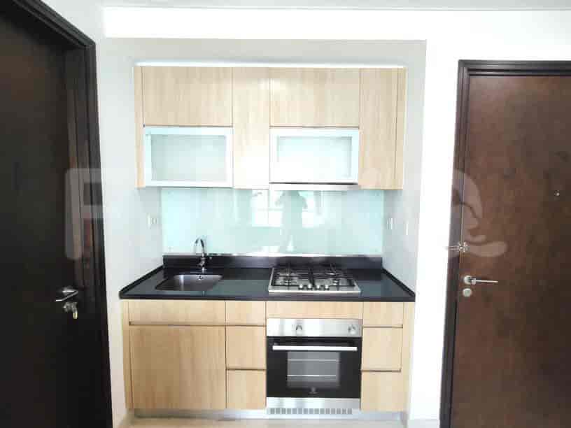 A compact kitchen with a stove, sink, and cabinets.
