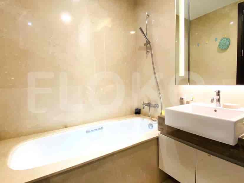 Kamar mandi mewah dengan bathtub, sentuhan marmer, dan wastafel modern.