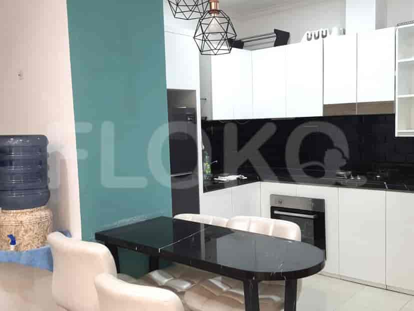 A modern kitchen with a dining area, featuring white cabinetry, black countertops, and a stylish dining table.