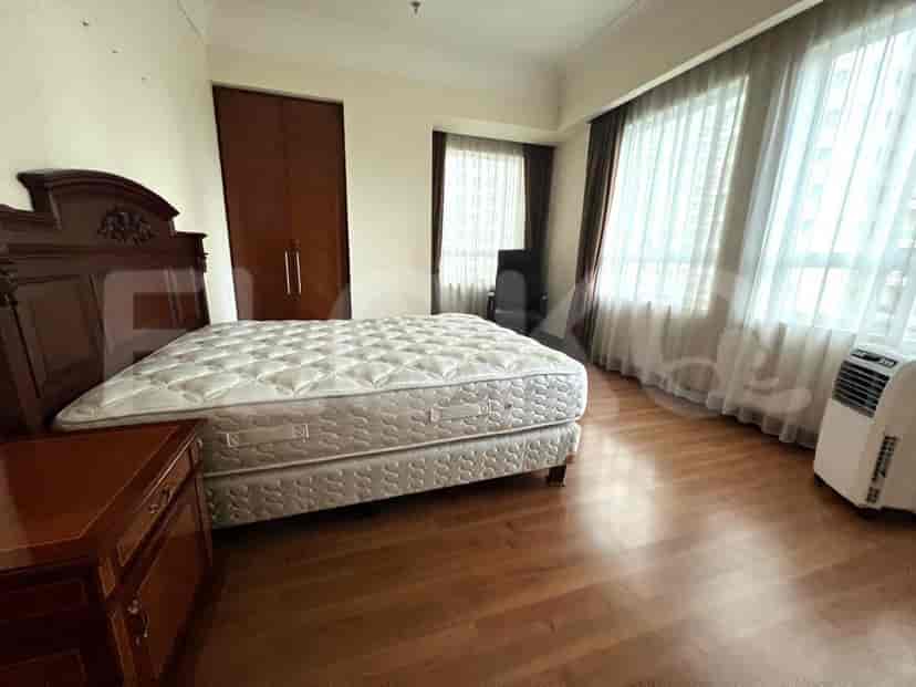 A bedroom with a bed, wardrobe and wooden flooring.