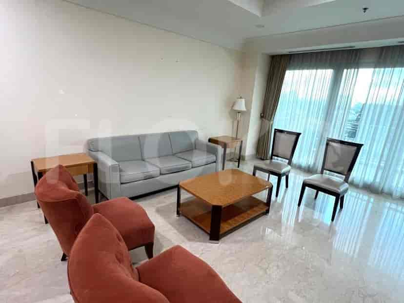 A living room with a grey sofa, armchairs, and a coffee table.