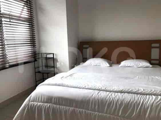 Bedroom with a bed, blinds, and a small shelf.