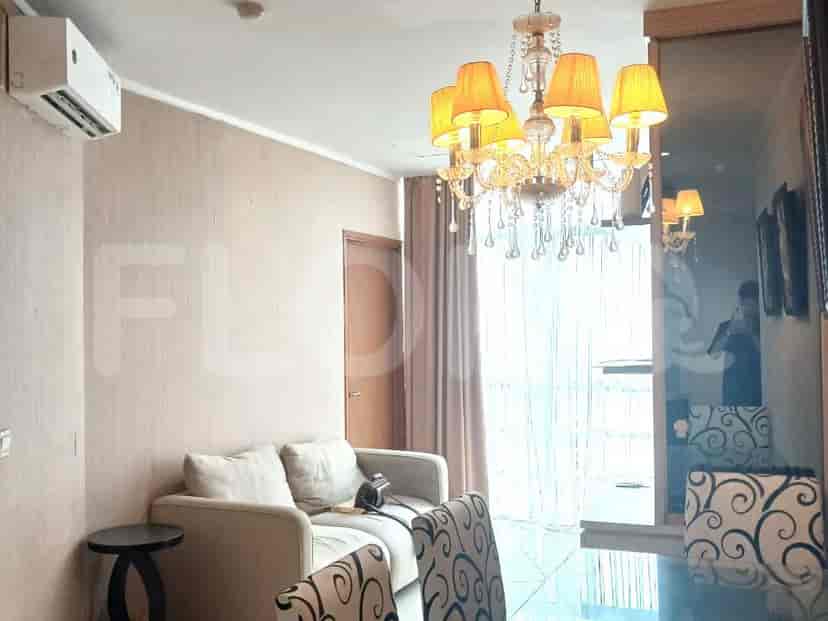 Living room with chandelier, sofa, and dining area.