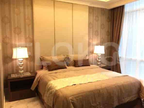 A bedroom with a king-size bed, upholstered headboard, and bedside tables with lamps.