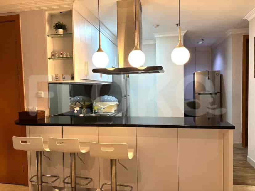 A kitchen island with bar stools and pendant lights.