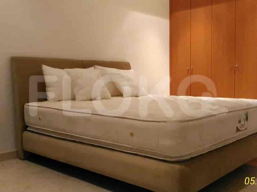 A bedroom with a large bed and a wooden wardrobe.