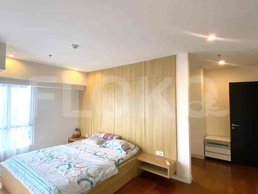 A bedroom with a queen-size bed, wooden headboard, and bedside tables.