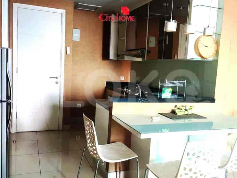 A kitchen area with modern cabinets, a dining table with chairs, and a refrigerator.