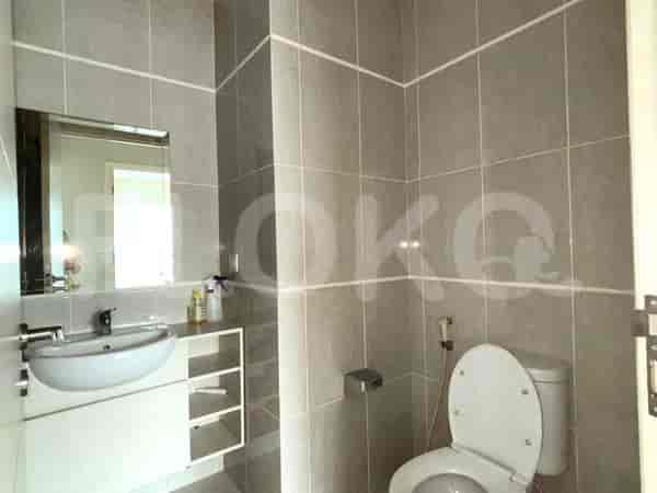 Kamar mandi dengan wastafel, toilet, dan dinding berubin.