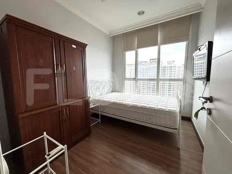 Kamar tidur kedua dengan tempat tidur tunggal, lemari pakaian kayu besar, dan jendela dengan pemandangan kota.