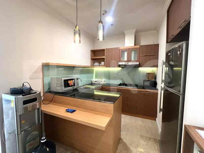 Dapur modern dengan lemari kayu, peralatan stainless steel, dan bar sarapan.