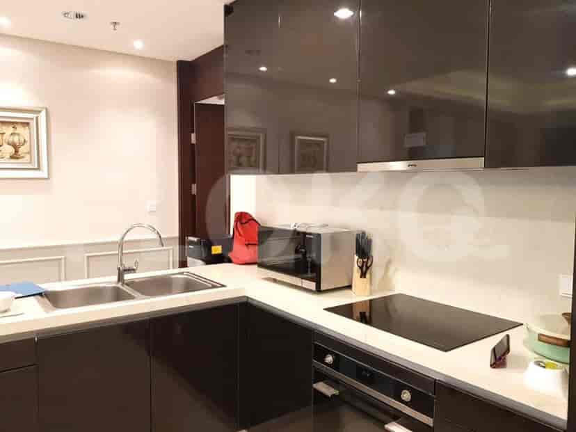 A modern kitchen with dark cabinets, a double sink, electric stove, and microwave.