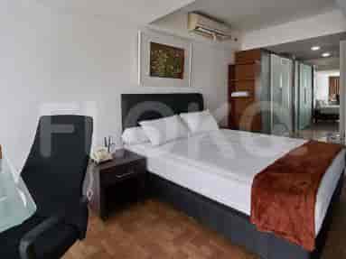 Kamar tidur dengan tempat tidur ukuran queen, nakas, kursi kantor, dan lemari besar.
