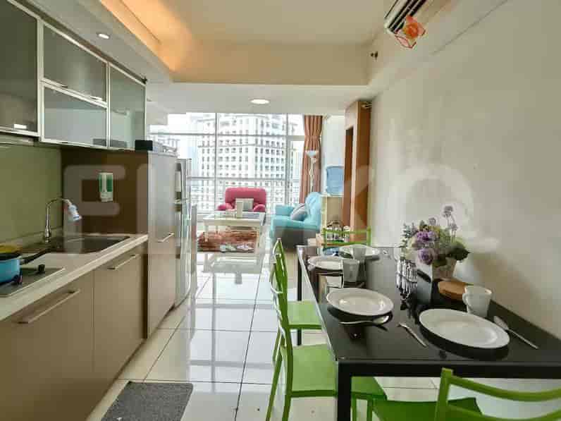 Dapur dan ruang makan terbuka dengan meja makan, kursi, meja dapur, dan kulkas.