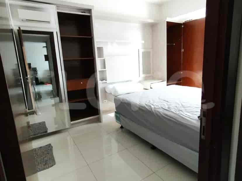 A bedroom with a bed, wardrobe, and shelves.