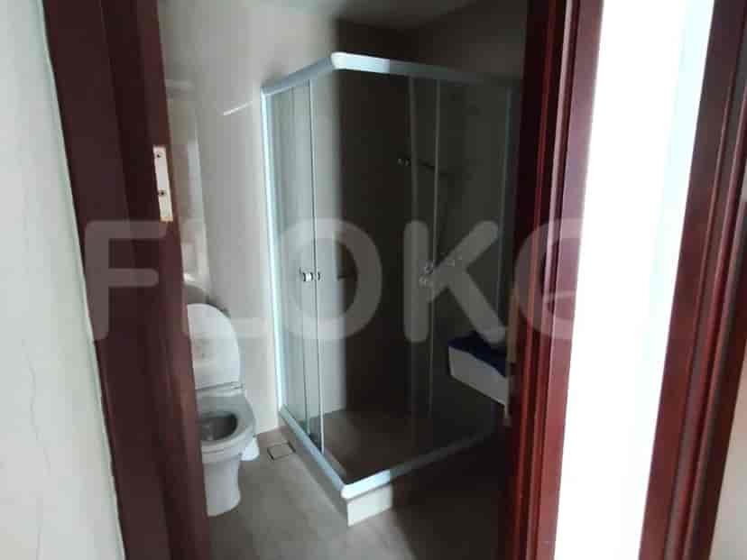 A bathroom with a toilet and a glass-enclosed shower.