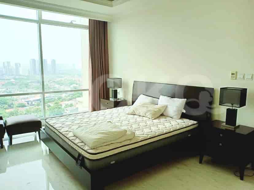 A cozy bedroom featuring a large bed, bedside tables with lamps, and a window with a city view.