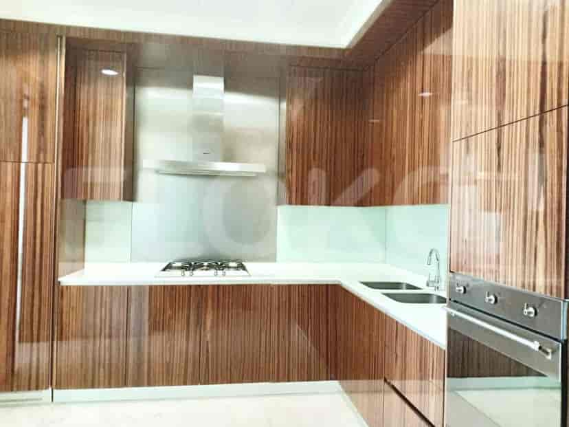 A modern kitchen with sleek wooden cabinets, a stainless steel backsplash, and integrated appliances.