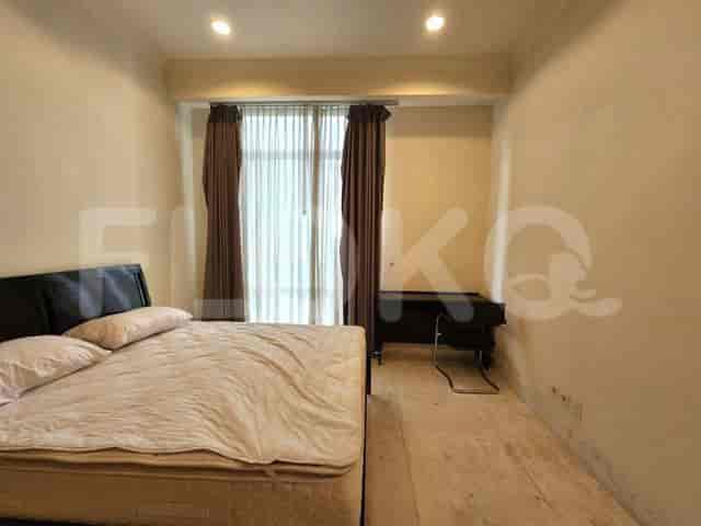 Kamar tidur dengan tempat tidur ukuran queen dan meja kayu gelap.