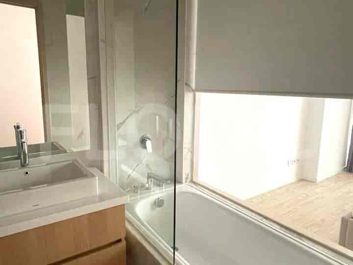 A modern bathroom featuring a bathtub, sink, and marble wall accents.