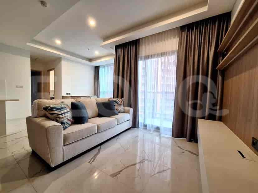 A bright living room with a beige sofa, marble floors, and large windows with curtains.