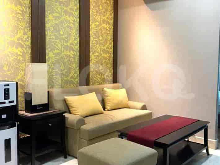 A cozy living area with a beige sofa, decorative pillows, a coffee table, and a water dispenser.