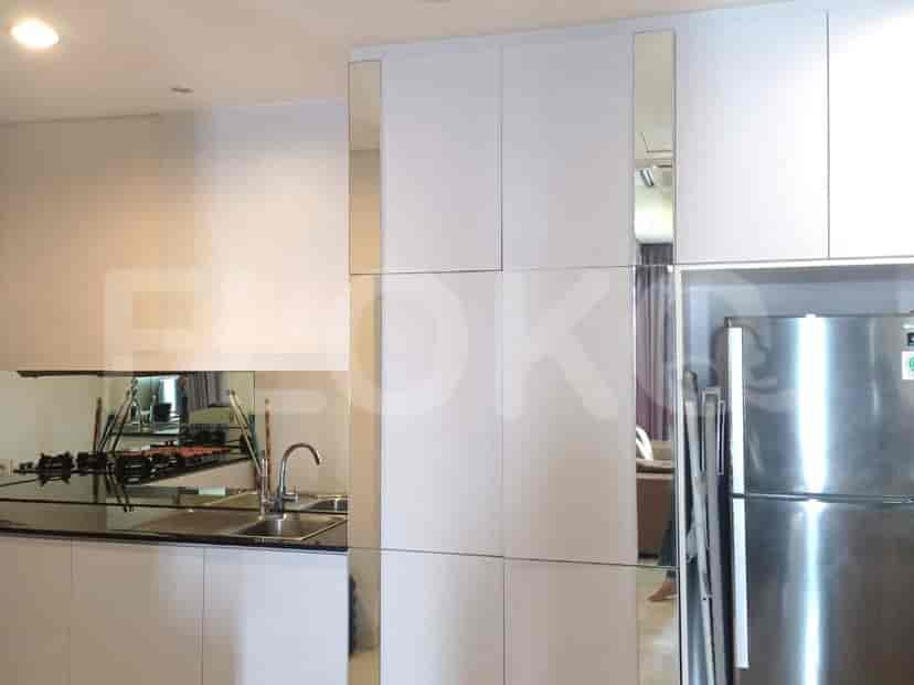 A compact kitchen with stainless steel appliances, a double sink, and white cabinetry.
