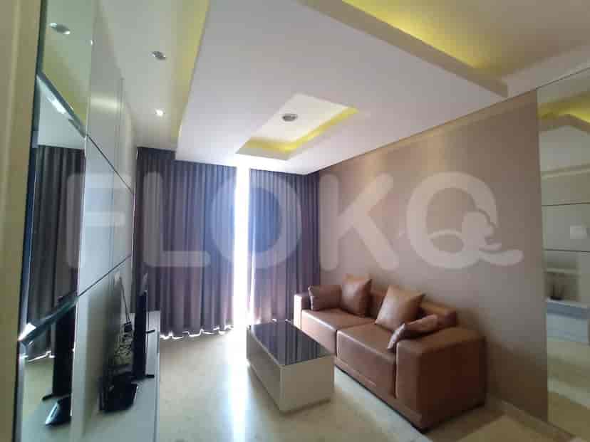 A modern living room featuring a comfortable brown leather sofa, a sleek coffee table, and a large window with draped curtains.