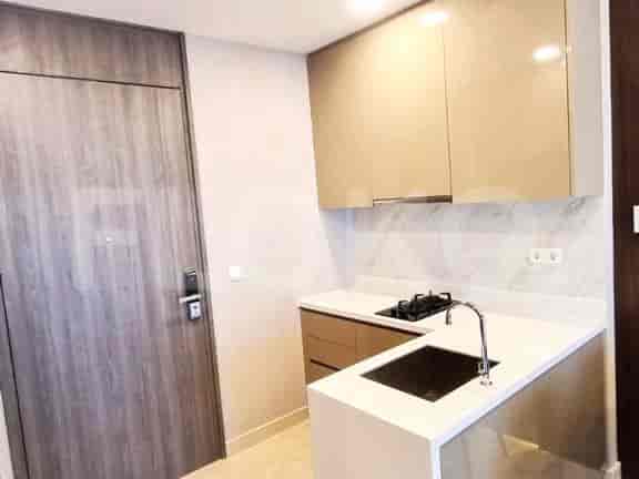 Dapur ringkas dengan lemari modern, meja, dan wastafel.