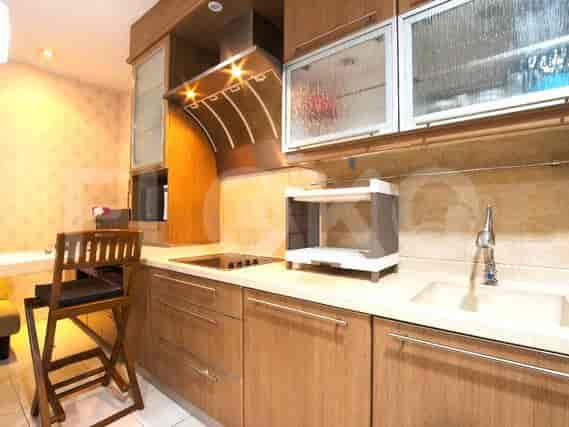 A modern kitchen with wooden cabinets, a countertop, an electric stove, and a chimney.