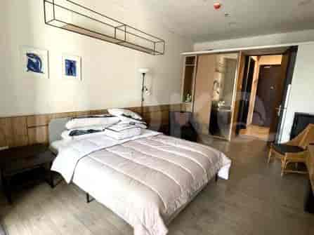 Kamar tidur dengan tempat tidur, meja samping tempat tidur, dan karya seni di dinding.