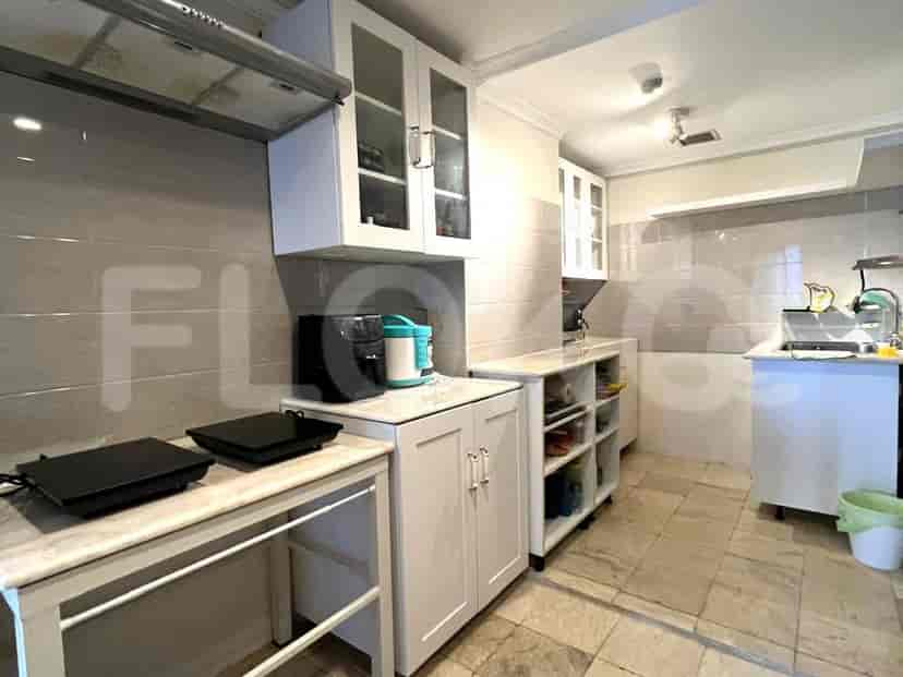 Dapur ringkas dengan lemari putih, kompor, dan wastafel.