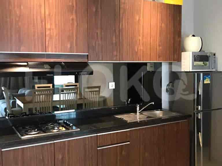 A modern kitchen with dark wood cabinets, a gas stove, and a stainless steel refrigerator.