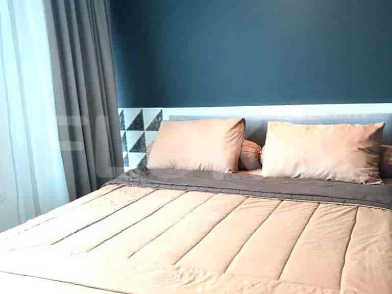 A bedroom with a large bed and a dark blue wall.