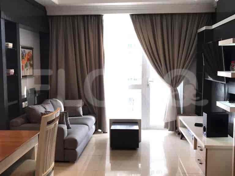 A modern living room with a grey sofa, dining table, large window with curtains, and a TV unit.