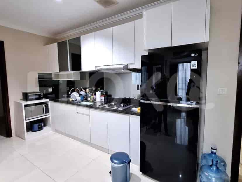A modern kitchen with white cabinets, a black countertop, and various appliances.