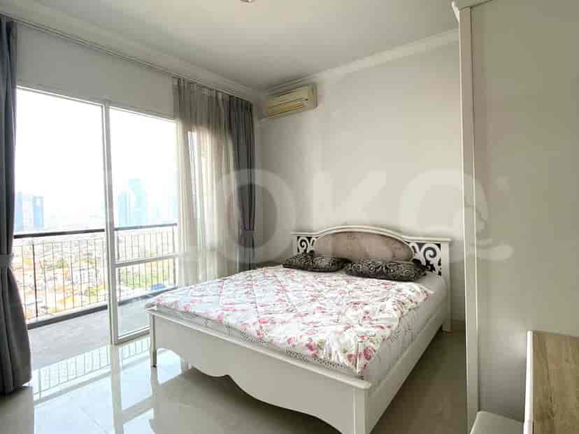 A bedroom with a queen-size bed, wardrobe, and a balcony.