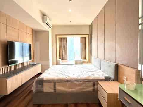 Kamar tidur dengan tempat tidur queen size, TV, dan lemari kayu.
