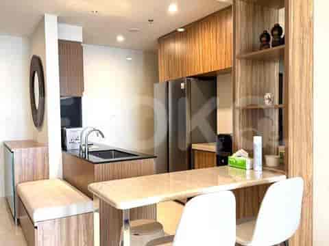 Dapur ringkas dengan bar sarapan, kulkas, dan lemari kayu.