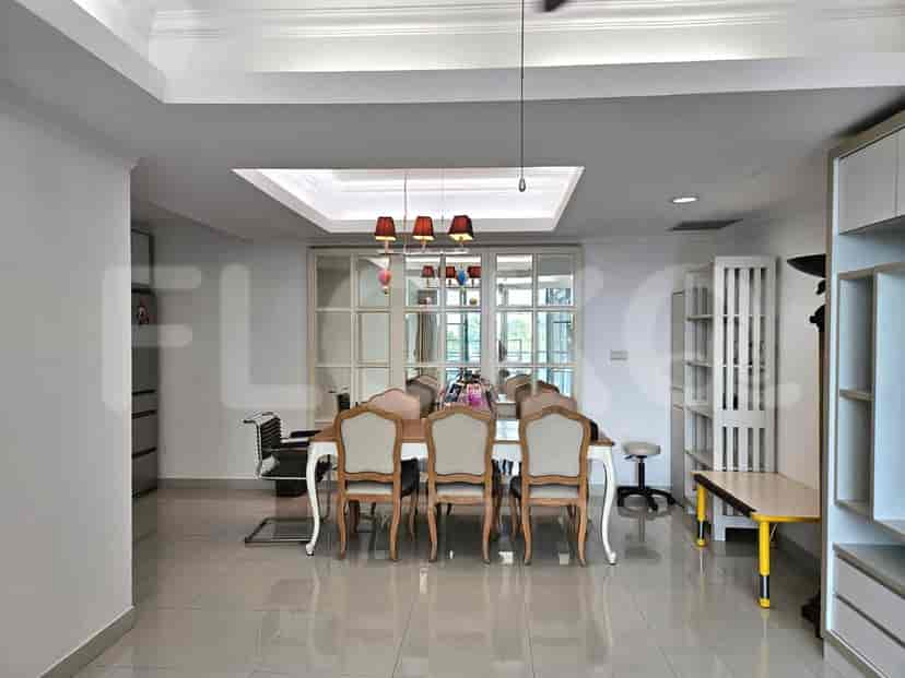 A formal dining room with a large wooden dining table, upholstered chairs, and decorative pendant lights.