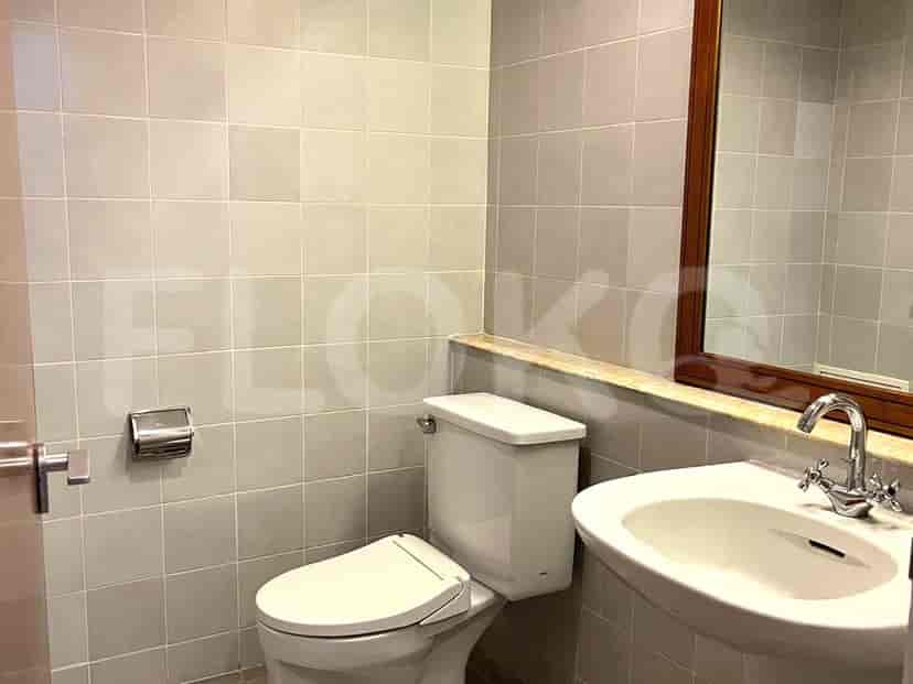 A small bathroom with a toilet, a sink, and a mirror.