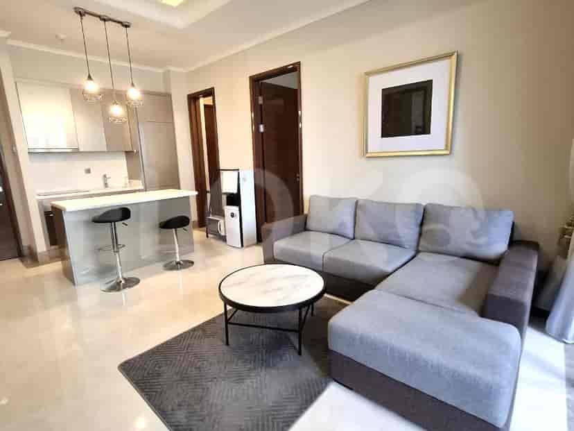 A contemporary living room with a sectional sofa, coffee table, and an open-plan kitchen.