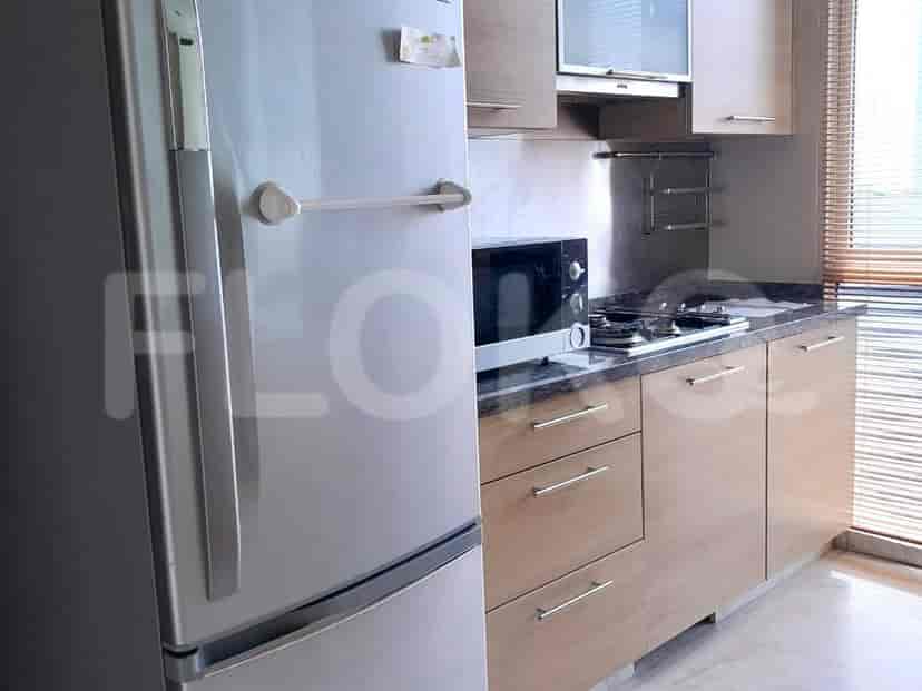 A modern kitchen with stainless steel appliances, including a refrigerator and microwave.