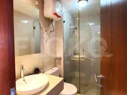 Kamar mandi dengan wastafel, toilet, dan pancuran kaca.