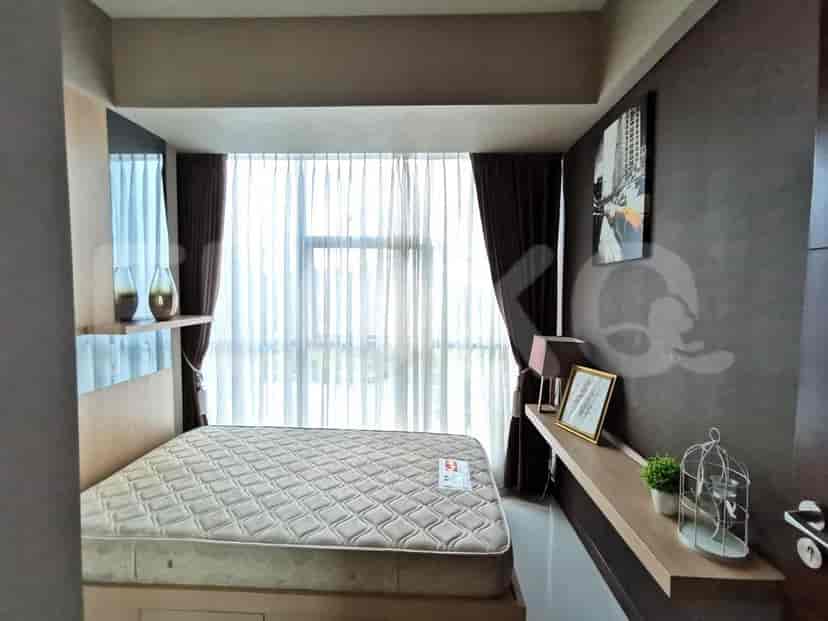 A bedroom with a mattress on a wooden frame, sheer curtains, and dark brown curtains.